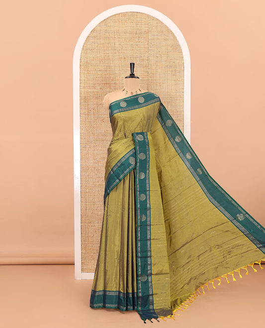 Green dobby style buttas semi-soft silk saree, contrast round buttas and striped border, striped pallu, and a plain blouse