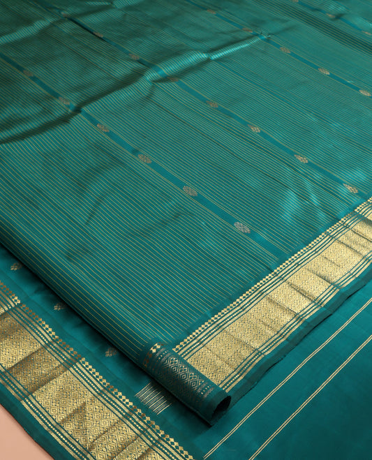 Green Kanchipuram Silk Saree, Subtly Sparkled with Stripes and Buttas, a Zari One-sided Border of Paneer Sombu, Banaras, Muthu, and Jaal Designs, Zari Design Pallu, and No Blouse