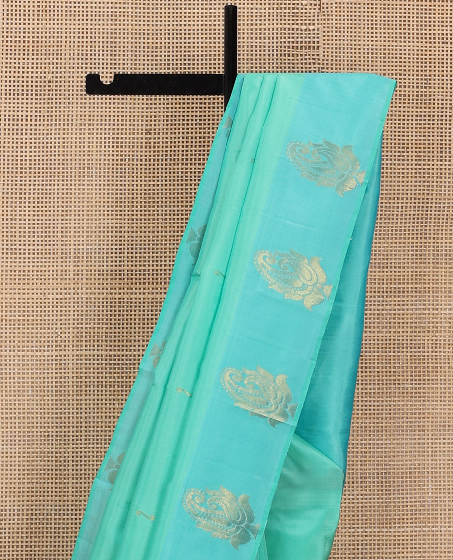 Turquoise Kanchipuram Silk Saree Woven with Zari Buttas, Subtly Sprakled Contrasting Border of Manga Designs, Zari Motifs Woven Pallu, and Paired with a Contrast Blouse