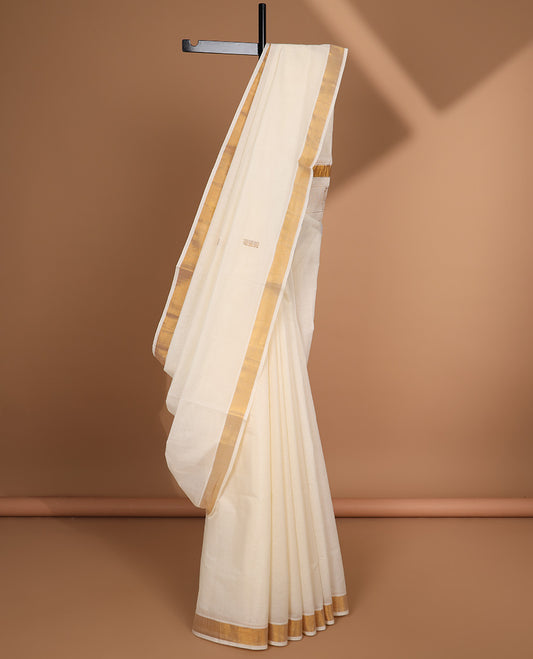 Cream kerala saree with zari buttas, plain border & pallu of peacock designs