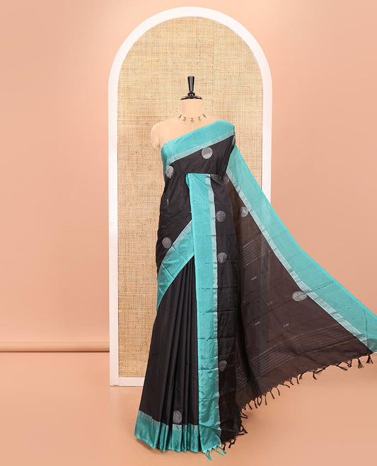 Black Semi-Soft Silk Saree Featuring Round Silver Zari Buttas Woven Across Its Body, Complemented by a Contrast Zari Design Border, Subtly Made Self-Pallu, and a Matching Blouse