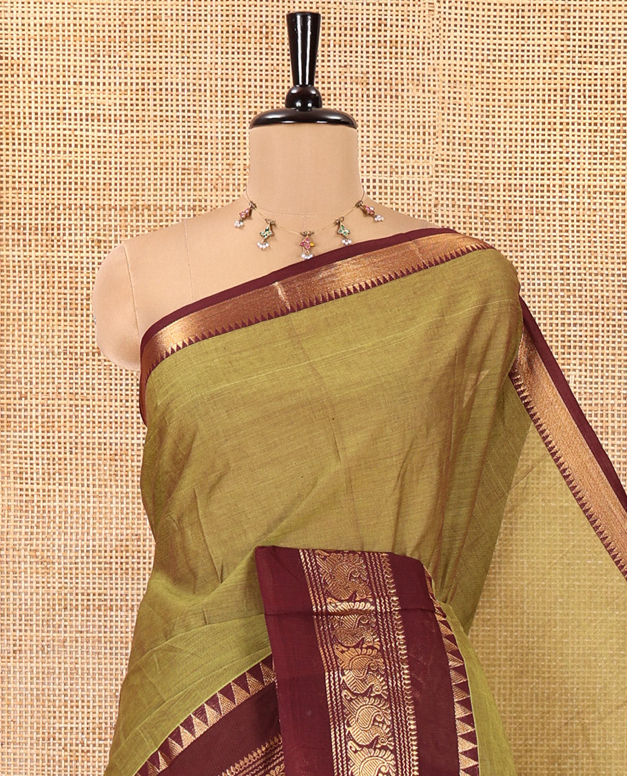 Leaf Green Plain Chettinad Cotton Saree, Complemented by Contrast Rettai Pettu Traditional Zari Border of Temple and Peacock Designs, Striped Pallu, and Paired with a Matching Blouse