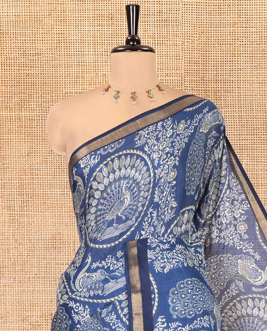 Indigo Blue Muslin Cotton Saree, Beautified with Round Peacock Motifs and Floral Print on Its Body, a Subtle Zari Border, Striped Pallu, and Matching Blouse