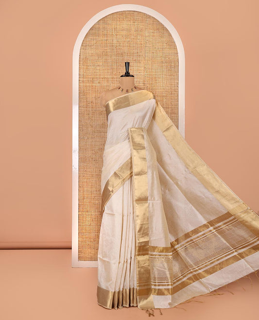 Cream Plain Art Tussar Saree, Highlighted by a Gleaming Golden Zari Bavanji Border, Pallu Steeped with Zari Stripes, and Paired with a Matching Blouse