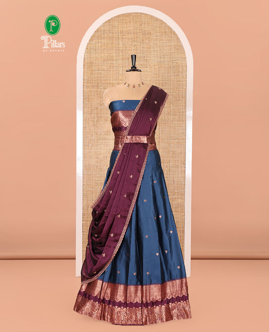 Blue-Purple Semi-Banarasi Half-Saree Enriched with Zari Buttas on Its Skirt, Complemented by a Contrast Traditional Zari Temple Rettai Pettu Border, Paired with a Matching Blouse, and a Satin Georgette Embroidered Scallop Dhavani