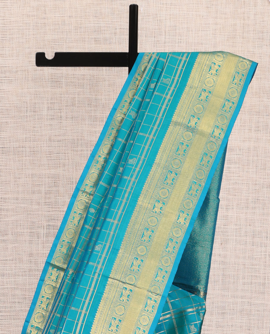 Neelambhari - Peacock Blue Vasundhara Silk Saree Gleamed Up with Zari Buttas Enclosed in Zari Checks, Featuring a Zari Border of Kuthirai and Chakra Designs, Rich Zari Pallu, with a Matching Blouse