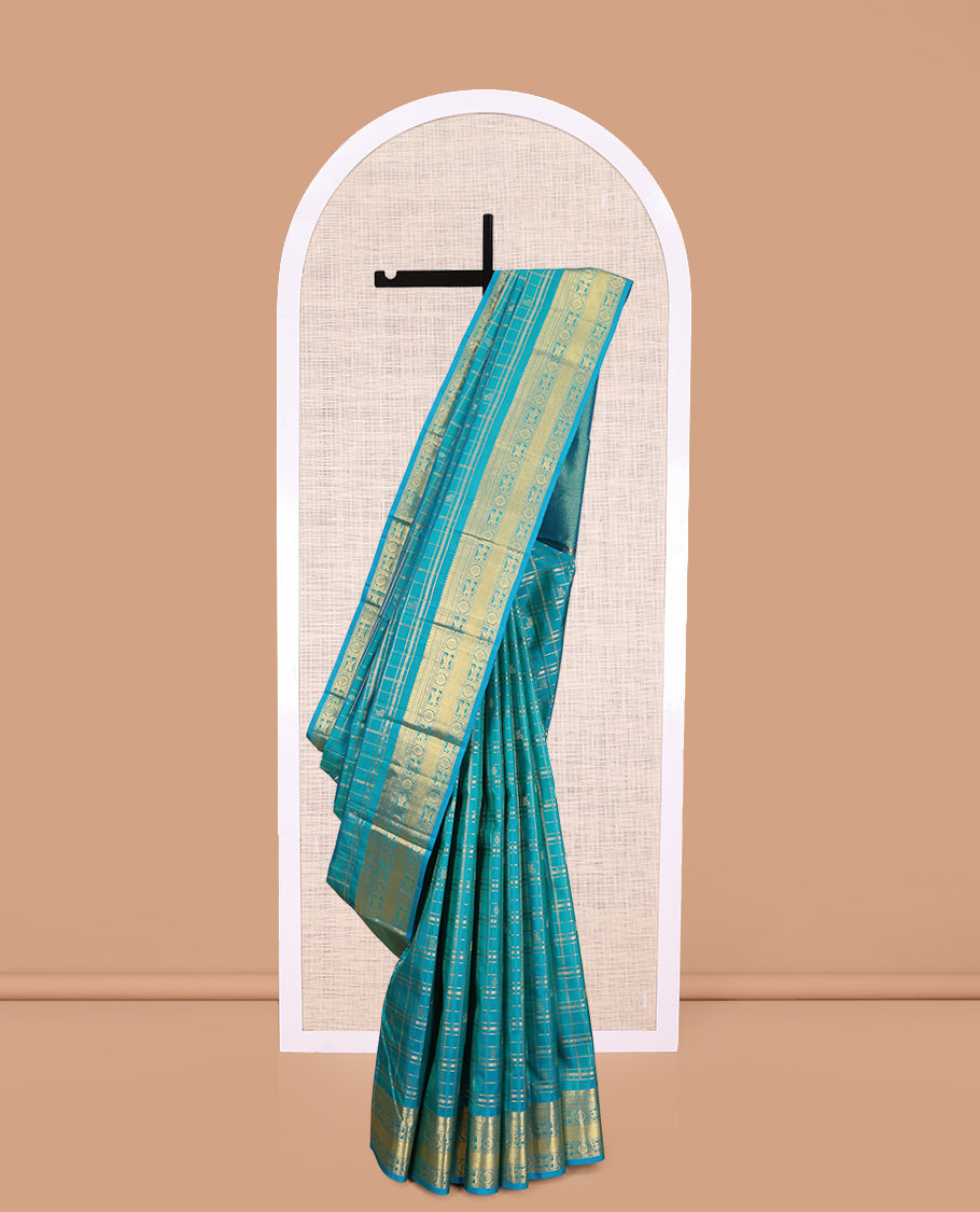 Neelambhari - Peacock Blue Vasundhara Silk Saree Gleamed Up with Zari Buttas Enclosed in Zari Checks, Featuring a Zari Border of Kuthirai and Chakra Designs, Rich Zari Pallu, with a Matching Blouse