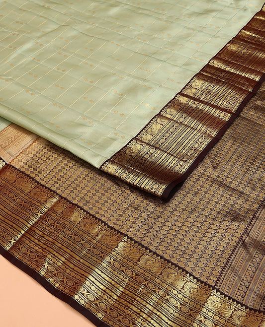 Green Vasundhara Lite Silk Mix Saree, Gracefully Detailed with Zari Butta Enclosed Checks on Its Body, Complemented by a Contrast Border of Rekku, Muthu, Banaras, Mayil, Rudraksham, and Kamalam Designs, Grand Jaal Pallu, and Paired with a Contrast Blouse