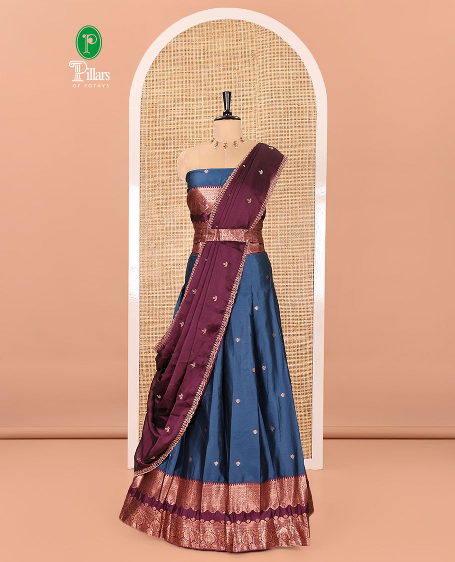 Blue-Purple Semi-Banarasi Half-Saree Enriched with Zari Buttas on Its Skirt, Complemented by a Contrast Traditional Zari Temple Rettai Pettu Border, Paired with a Matching Blouse, and a Satin Georgette Embroidered Scallop Dhavani
