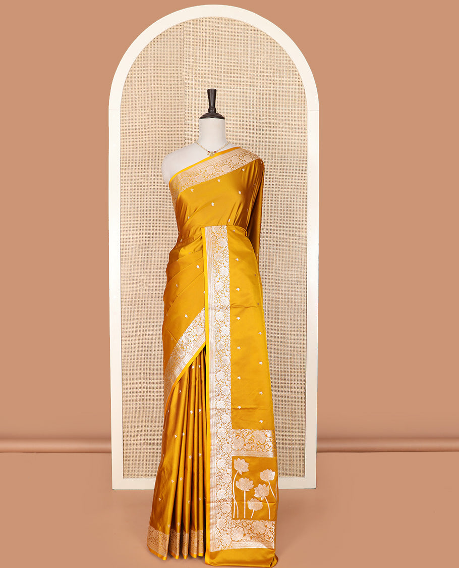 Yellow Semi-Banaras Satin Saree Subtly Sparkled with Zari Buttas, Self-Border Gleamed Up with Floral Creeper Designs, Pallu Creatively Woven of Lotus Motifs, and Paired with a Matching Blouse