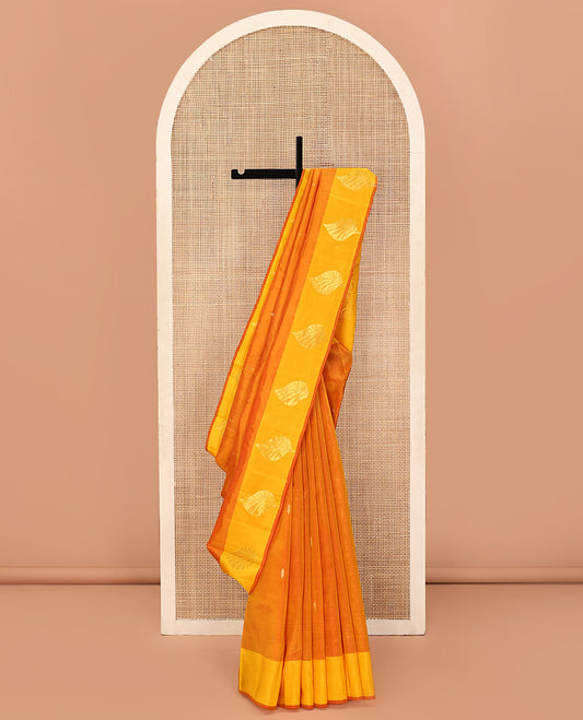 Orange Kanchipuram Silk Saree, Adorned with Zari Buttas All Over Its Body, Complemented by a Contrast Border of Leaf Designs, Pallu of Floral Designs, and Paired with a Contrast Blouse