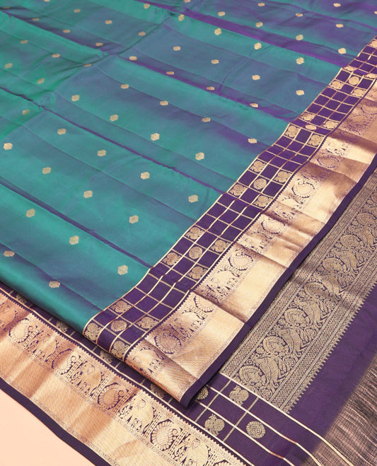 Blue Vasundhara Lite Silk Mix Saree, Ornamented With Zari Buttas All Over Its Body, Complemented by Contrast Border of Mayil-Chakram Enclosed Checks, Yaanai, and Arumbu Manga Designs, Grand Jaal Pallu and Paired with a Contrast Blouse