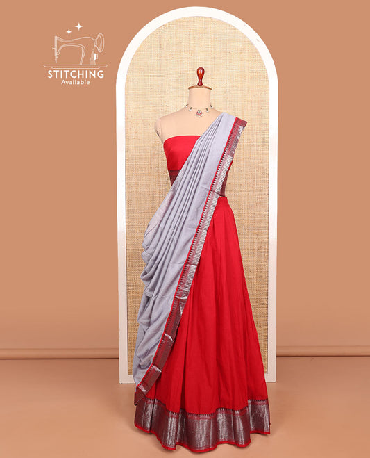 Red plain cotton half-saree with traditional bordered skirt, matching blouse, and a contrast traditional bordered dhavani