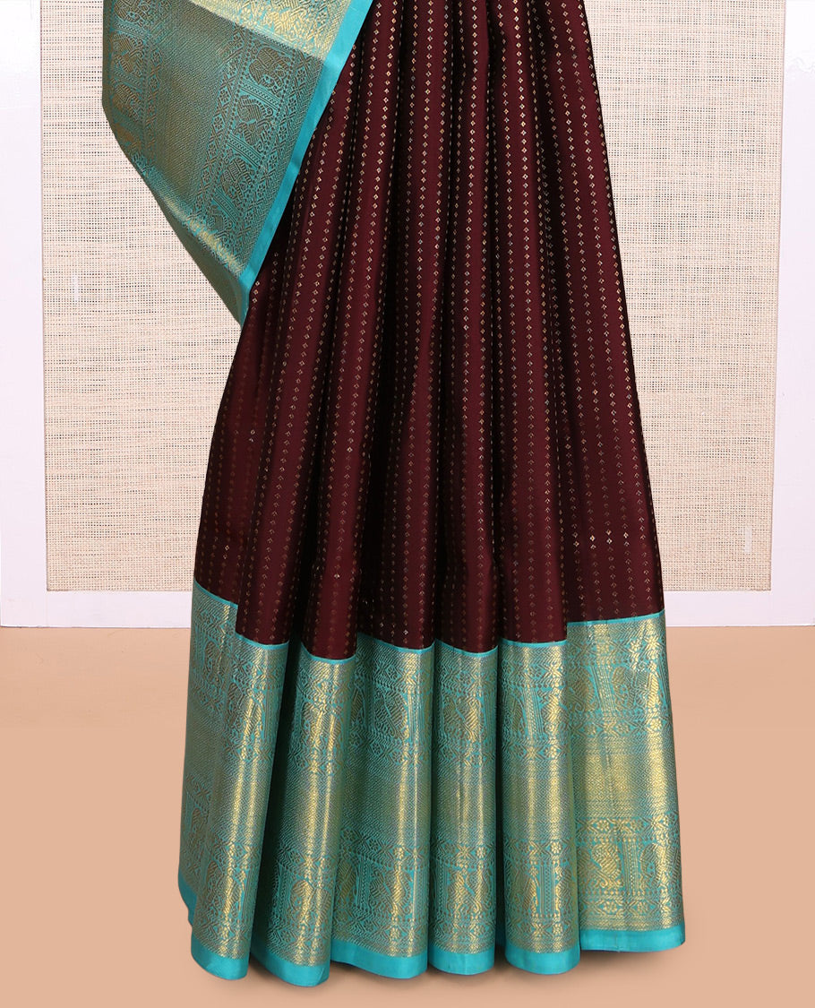 Brown Vasundhara Silk Saree Delicately Woven with Zari Buttas, Highlighted with a Contrast Border of Cross Kamalam, Mayil, Banaras, Yaanai, and Mayil Kann Designs, Pallu Grandly Woven with Jaal Designs, and Paired with a Contrast Blouse