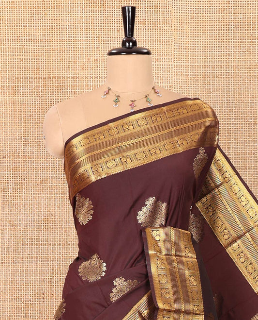 Coffee Brown Kanchipuram Budget Silk Saree Gleamed Up with Zari Buttas, Highlighted by Zari Border of Peacock Chakram Designs, Pallu Richly Detailed with Kolam and Chariot Designs, and Paired with a Matching Blouse