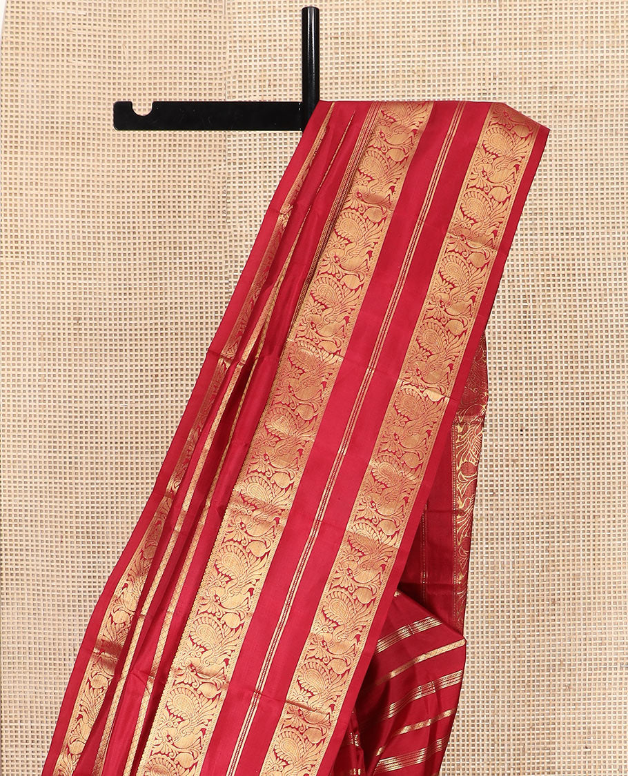 Red Vasundhara Silk Saree Majestically Detailed with Zari Designs, Highlighted by a Zari Border of Muthu, Banaras, and Mayil Designs, Grandly Detailed Pallu of Jaal Design, and a Matching Blouse