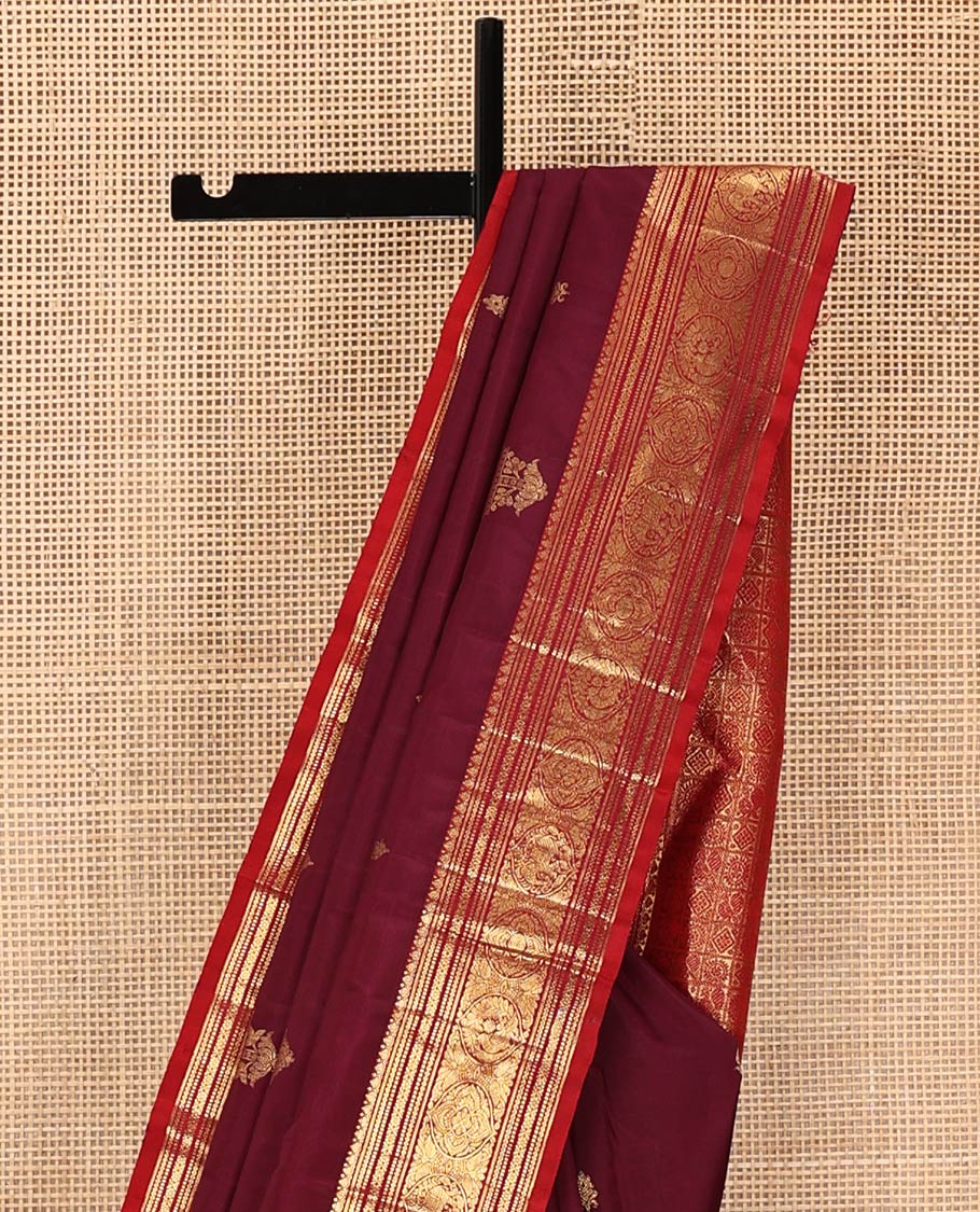 Maroon Kanchipuram Silk Saree, Bedecked with Zari Buttas All Over Its Body, Complemented by a Contrast Border of Neli, Muthu, Cross Kamalam, and Mayil Designs, Pallu of Butta Enclosed Checked Designs, and Paired with a Contrast Blouse