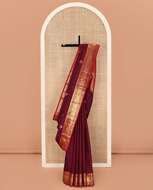 Maroon Kanchipuram Silk Saree, Bedecked with Zari Buttas All Over Its Body, Complemented by a Contrast Border of Neli, Muthu, Cross Kamalam, and Mayil Designs, Pallu of Butta Enclosed Checked Designs, and Paired with a Contrast Blouse