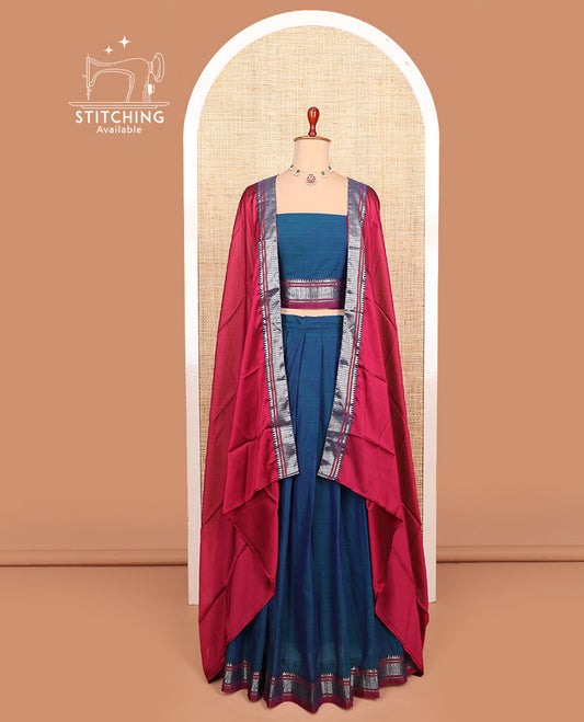 Blue plain cotton half-saree with traditional bordered skirt, matching blouse, and a contrast traditional bordered dhavani