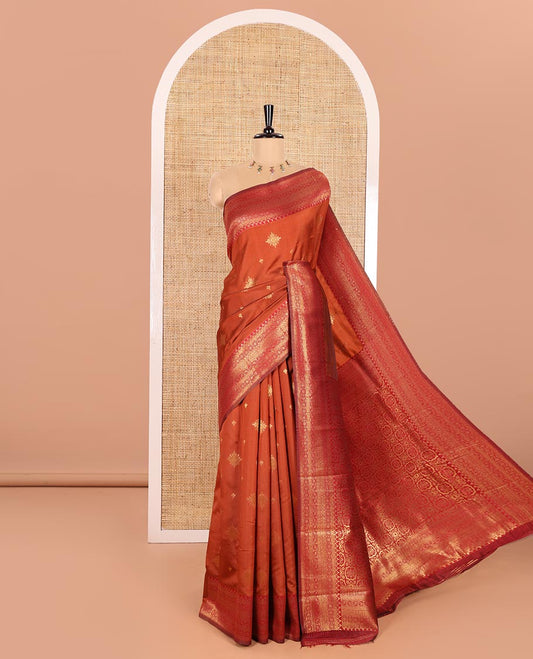 Rust Orange Kanchi Silk Saree Graced with Gold Zari Buttas Woven All Over Its Body, Complemented by Contrast Traditional Zari Design Border, Pallu Majestically Detailed with Intricate Zari Designs, and Paired with a Contrast Blouse