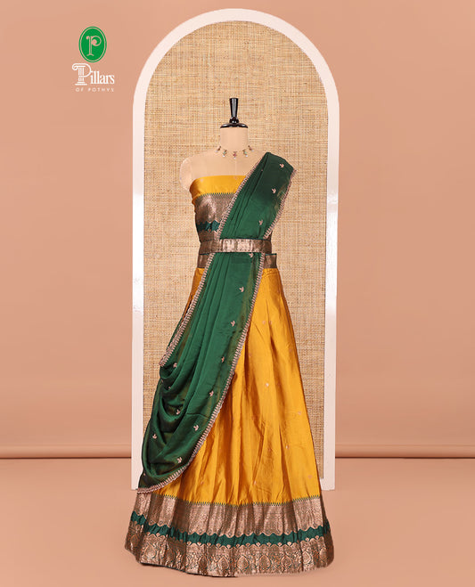 Yellow-Green Semi-Banarasi Half-Saree Subtly Sparkled with Zari Buttas on Its Skirt, Complemented by a Contrast Traditional Zari Temple Rettai Pettu Border, Paired with a Matching Blouse, and a Satin Georgette Embroidered Scallop Dhavani