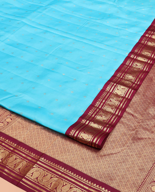 Blue Vasundhara Silk Saree Gleamed Up with Zari Buttas, Highlighted by a Contrast Border of Thilakam Mokku, Banaras, Kathir, and Manga Designs, Grandly Detailed Pallu of Jaal Design, and a Contrast Blouse