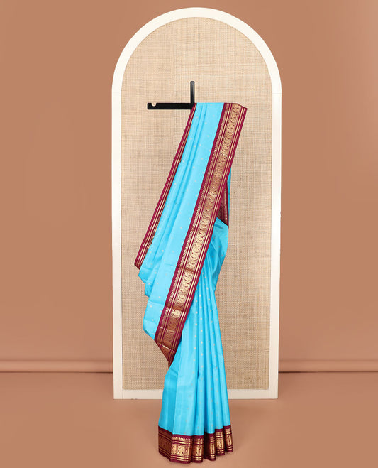 Blue Vasundhara Silk Saree Gleamed Up with Zari Buttas, Highlighted by a Contrast Border of Thilakam Mokku, Banaras, Kathir, and Manga Designs, Grandly Detailed Pallu of Jaal Design, and a Contrast Blouse