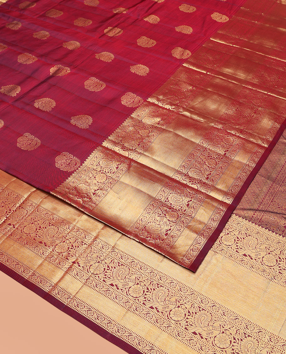 Maroon Vasundhara Silk Saree Ornamented with Zari Buttas All Over Its Body, Highlighted by Zari Border of Rekku, Kodi Visiry, Mayil, and Kuyil Kann Designs, a Grand Pallu of Diagonal Stripes, and Paired with a Matching Blouse