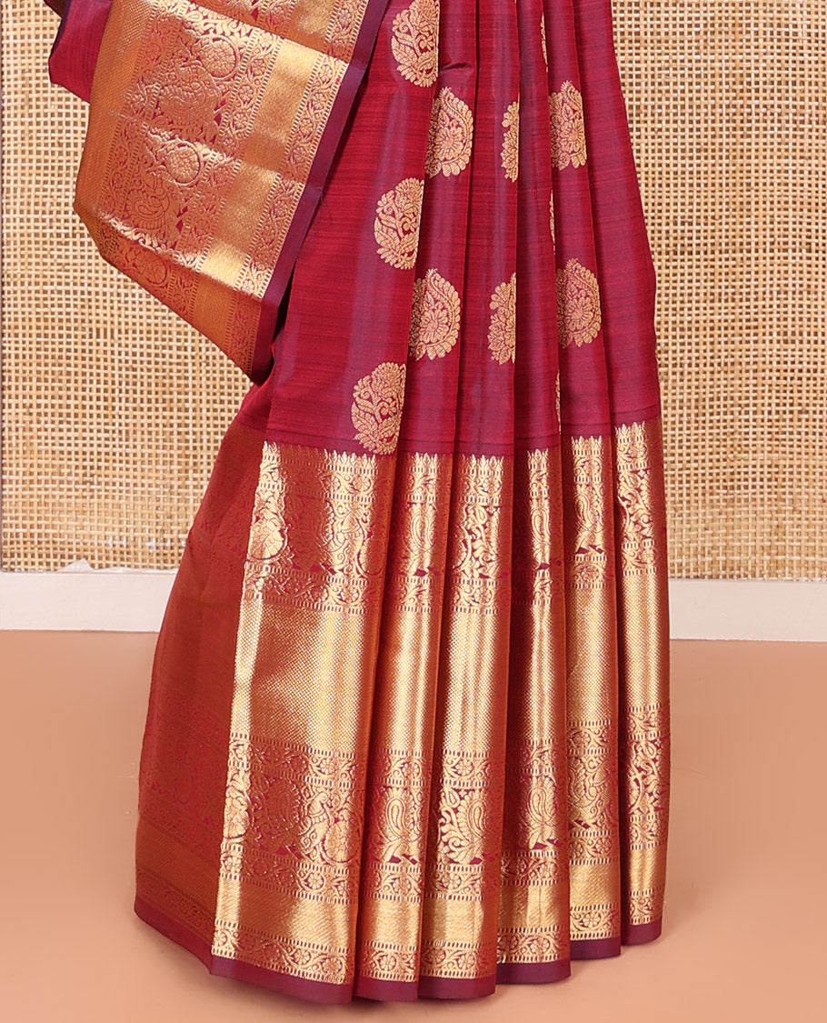 Maroon Vasundhara Silk Saree Ornamented with Zari Buttas All Over Its Body, Highlighted by Zari Border of Rekku, Kodi Visiry, Mayil, and Kuyil Kann Designs, a Grand Pallu of Diagonal Stripes, and Paired with a Matching Blouse