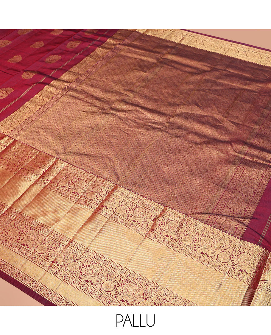 Maroon Vasundhara Silk Saree Ornamented with Zari Buttas All Over Its Body, Highlighted by Zari Border of Rekku, Kodi Visiry, Mayil, and Kuyil Kann Designs, a Grand Pallu of Diagonal Stripes, and Paired with a Matching Blouse