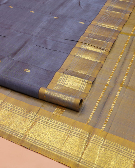 Grey Kanchipuram Silk Saree, Graced with Zari Buttas on Its Body, Complemented by a Contrast One-Sided Border of Panner Sombu, Banaras, Muthu, and Jaal Designs, Pallu of Zari Designs, and Comes Without a Blouse