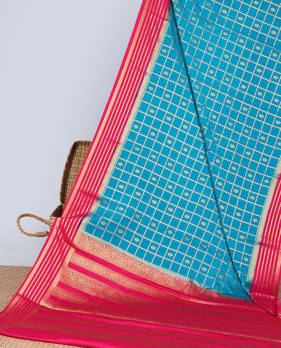 Blue floral motifs enclosed checked with contrast striped zari border & pallu of intricate design