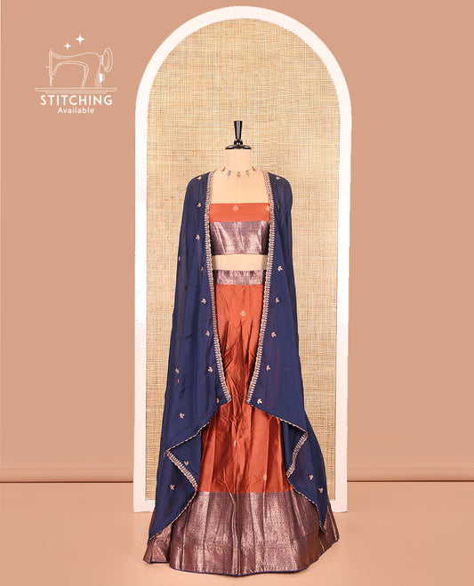 Rust and Navy Blue Semi-Banarasi Half-Saree, Embellished with Zari Buttas on Its Skirt, Complemented by a Contrast Traditional Zari Designs Woven Border, Paired with a Matching Blouse, and a Contrast Satin Georgette Embroidered Scallop Dhavani