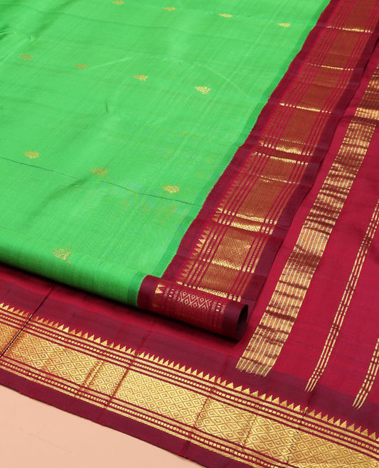Green Kanchipuram Silk Saree, Embellished with Zari Buttas on Its Body, Complemented by a Contrast One-Sided Korvai Border of Rekku, Banaras, Muthu, and Mayil Kann Designs, Pallu Features Zari Designs, and Comes Without a Blouse