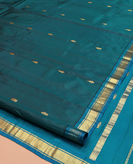 Blue Kanchipuram Silk Saree, Adorned with Zari Buttas on Its Body, Complemented by a Contrast One-Sided Border of Banaras, and Mayil Kann Designs, Pallu Steeped with Zari Designs, and Comes Without a Blouse