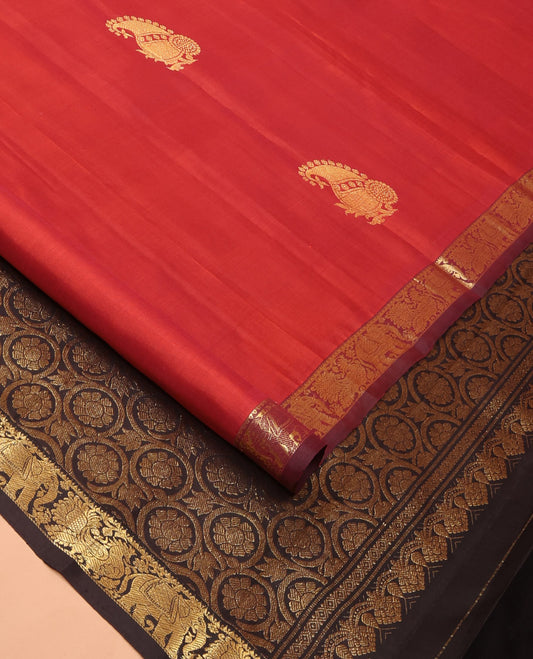 Red Kanchipuram Silk Saree Mesmerized with Zari Buttas, Complemented by a Contrast Border Featuring Rekku, Yaanai, and Mayil Designs, Pallu Artfully Woven in Floral Jaal Designs, and Paired with a Contrast Blouse