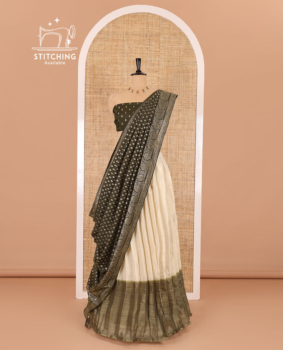 Cream-olive green Vichitra half-saree, plain and contrast bordered skirt, contrast leaf buttas blouse, dhavani of buttas and floral creeper designs