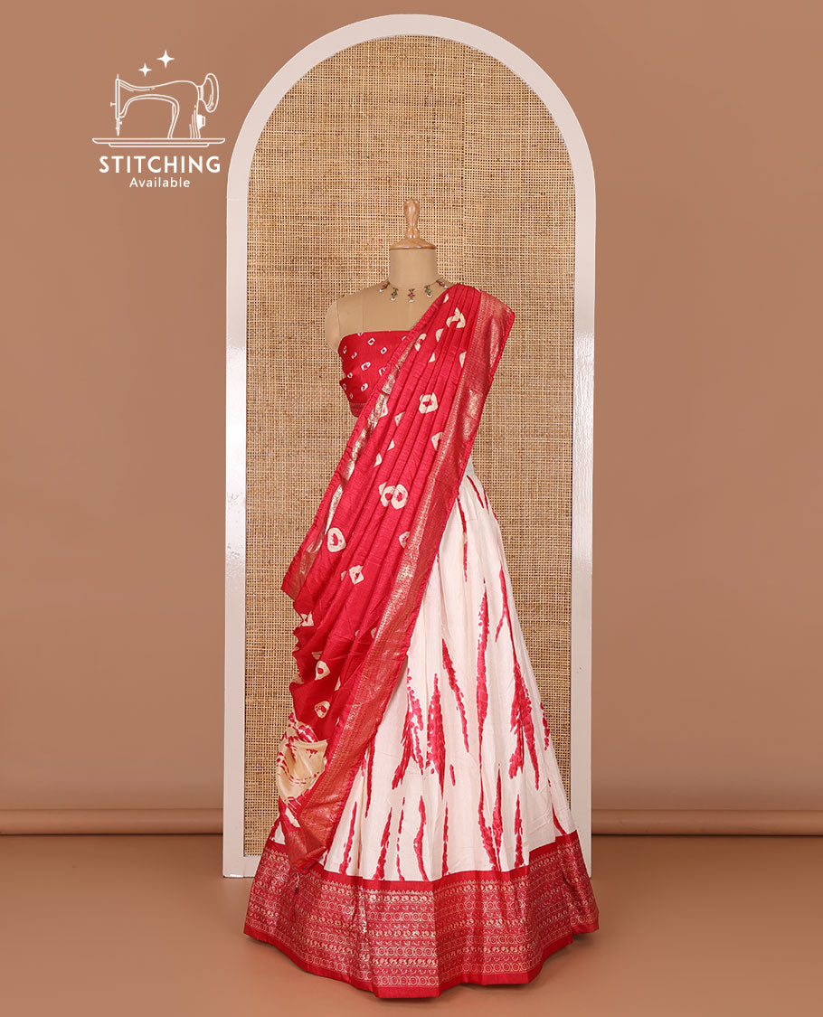 Cream and pink semi-tussar half-saree, shibori printed with contrast geometric patterned bordered skirt, bandhani printed blouse, and bandhani printed dhavani