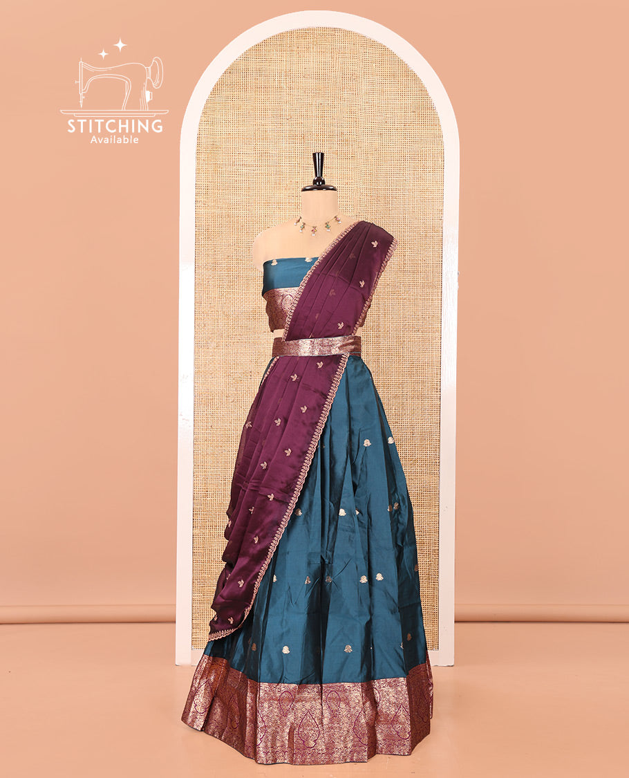 Peacock Blue and Magenta Semi-Banarasi Half-Saree, Accentulated with Zari Buttas on Its Skirt, Complemented by a Contrast Intricately Zari-Designed Border, Paired with a Matching Blouse, and a Contrast Satin Georgette Embroidered Scallop Dhavani
