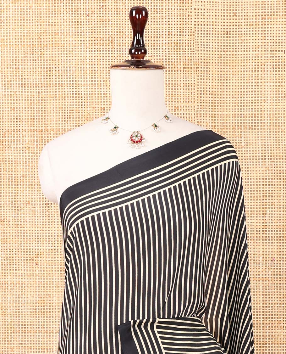 Black vertical stripes printed modal satin saree, a self-border of horizontal stripes print, polka dots printed on the pallu, and an intricate ajrakh-style printed blouse