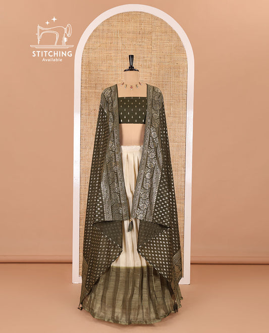 Cream-olive green Vichitra half-saree, plain and contrast bordered skirt, contrast leaf buttas blouse, dhavani of buttas and floral creeper designs