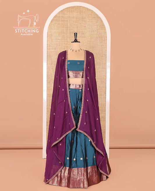 Blue and Purple Semi-Banarasi Half-Saree, Elevated with Zari Buttas on Its Skirt, Complemented by a Contrast Traditional Zari Designs Woven Border, Paired with a Matching Blouse, and a Satin Georgette Embroidered Scallop Dhavani