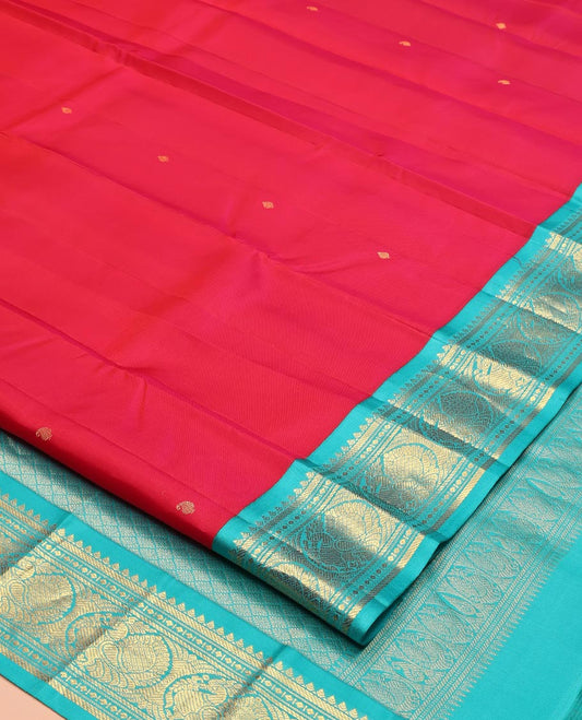 Red Vasundhara Silk Saree, Sparsely Woven with Zari Buttas All Over Its Body, Complemented by a Contrast Border of Rekku, Banaras, Diamond, and Round Mayil Designs, Grand Jaal-Patterned Pallu, and Paired with a Contrast Blouse