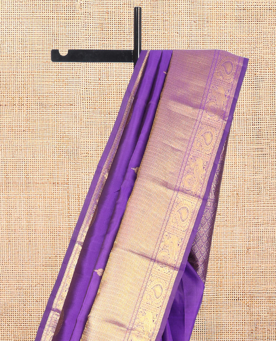 Violet Kanchipuram Silk Saree, Opulently Embellished with Jhumka Zari Buttas, Highlighted by a Zari Border of Arumbu Manga, Mayil, and Paiyadi Kann, Grand Pallu, and Matching Blouse