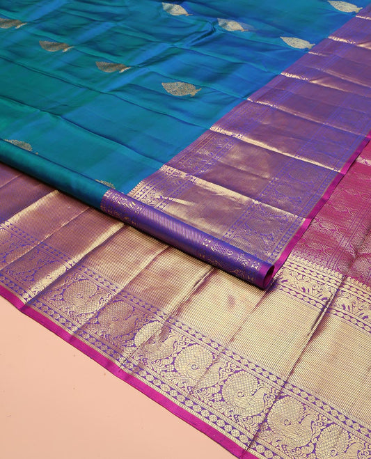 Blue Kanchipuram Silk Saree, Embellished with Zari Buttas All Over Its Body, Complemented by a Contrast Border of Manga Mokku, Poun, Yaali, and Mayil Designs, Pallu of Kodi Visiry Designs, and Paired with a Contrast Blouse