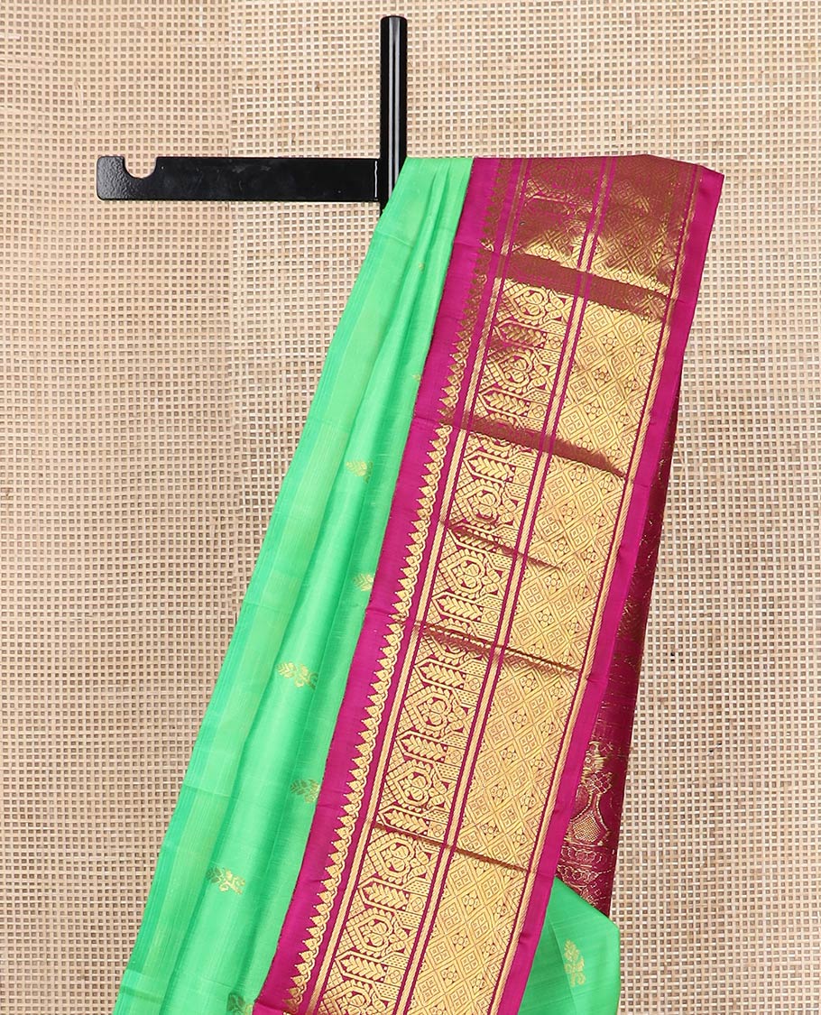 Green floral meena buttas Kanchipuram silksaree, contrast one-sided korvai border of thilakam mokku, manga & jaal & peacock inside palanquin design pallu