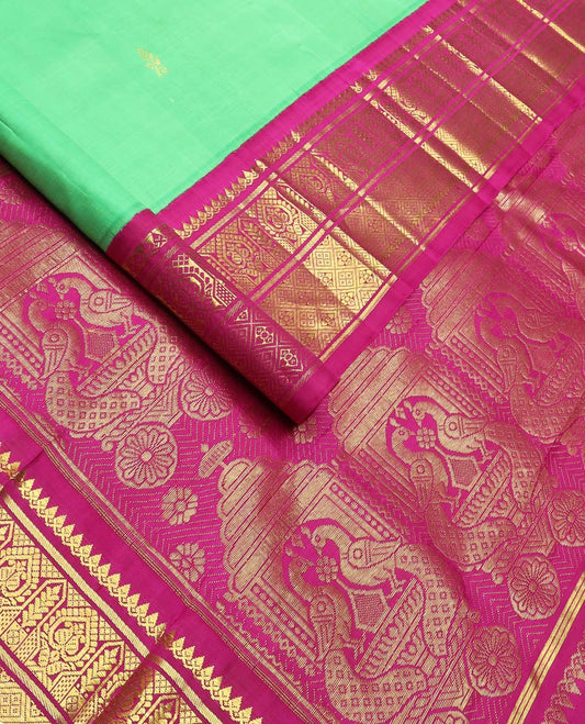 Green floral meena buttas Kanchipuram silksaree, contrast one-sided korvai border of thilakam mokku, manga & jaal & peacock inside palanquin design pallu