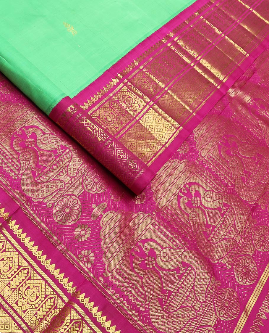 Green floral meena buttas Kanchipuram silksaree, contrast one-sided korvai border of thilakam mokku, manga & jaal & peacock inside palanquin design pallu