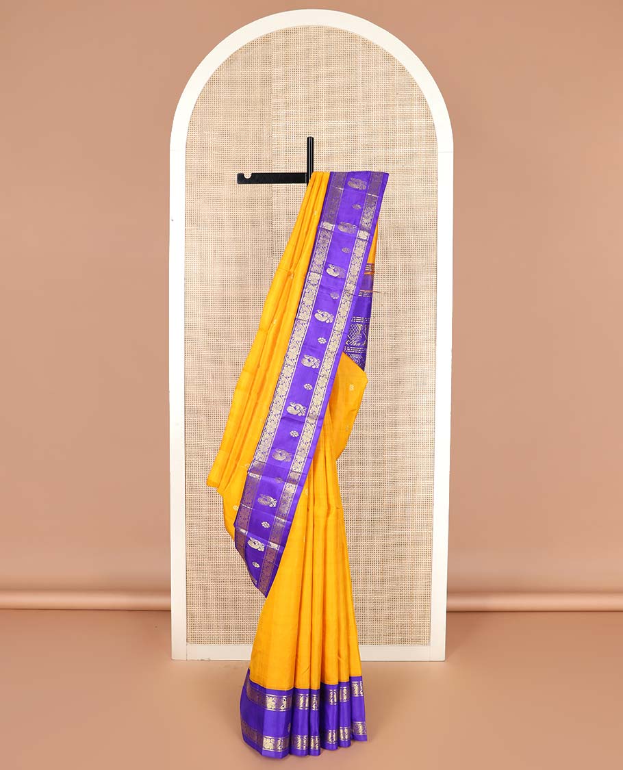 Yellow zari buttas Kanchipuram silk saree, contrast korvai one-sided border of mayil, kamalam, and kodi visiry designs, and pallu of intricate designs