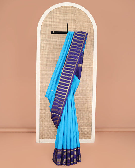 Blue Kanchipuram Silk Saree, Embellished with Zari Buttas, Complemented by Contrast One-Sided Korvai Border of Thilakam Mokku and Banaras Designs, Pallu Steeped with Floral Designs, and Comes Without a Blouse
